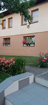 a building with flowers and a bench in front of it at Guest House Visoko in Visoko