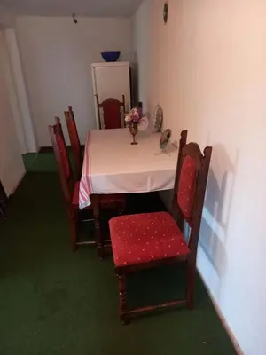 a table with chairs and a vase of flowers on it at Guest House Visoko in Visoko