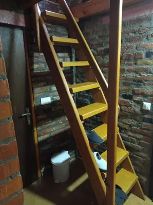 a wooden staircase in a room with a brick wall at Vila Zlaja in Bihać