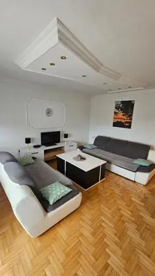 a living room with two beds and a table at Doboj Apartman in Doboj
