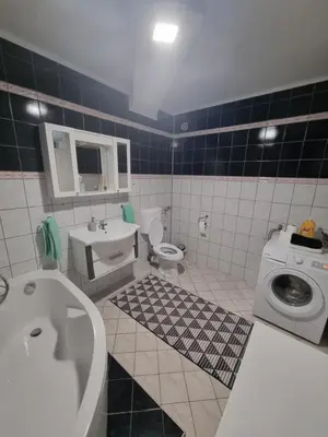 a bathroom with a sink toilet and a washing machine at Doboj Apartman in Doboj