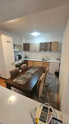 a kitchen with a table and a dining room at Doboj Apartman in Doboj