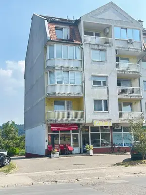 a tall building with a store in front of it at Doboj Apartman in Doboj