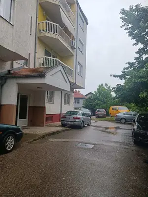 a parking lot with cars parked in front of a building at Doboj Apartman in Doboj
