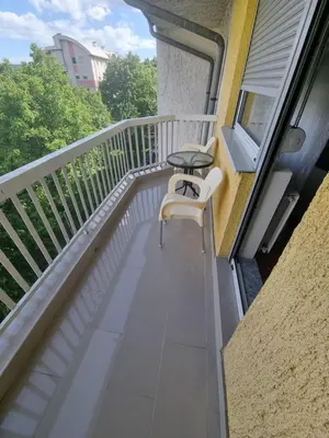 a balcony with a table and a chair on it at Doboj Apartman in Doboj