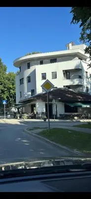 a street sign in front of a large building at Apartman My Choice in Bihać