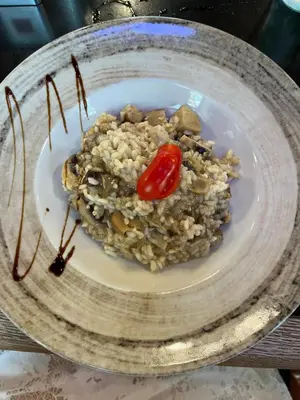 a plate of rice with a tomato on it at Apartman My Choice in Bihać