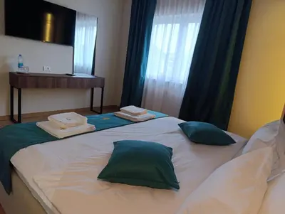 a bed with two pillows on top of it at Apartmani Leburic in Prnjavor