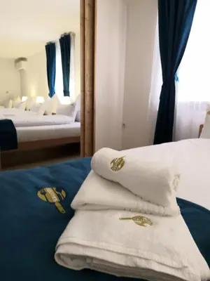 a room with two beds with white towels and a mirror at Apartmani Leburic in Prnjavor