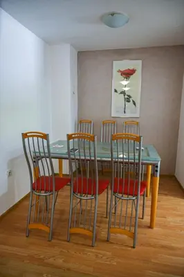 a dining room with a table and four chairs at Apartmani Leburic in Prnjavor