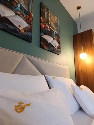 a bed with white sheets and pillows in a room at Apartmani Leburic in Prnjavor