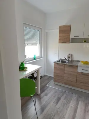 a kitchen with a desk and a green chair at Volijak 18 in Jajce