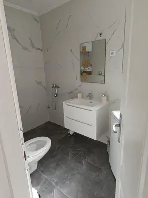 a white bathroom with a toilet and a sink at Volijak 18 in Jajce