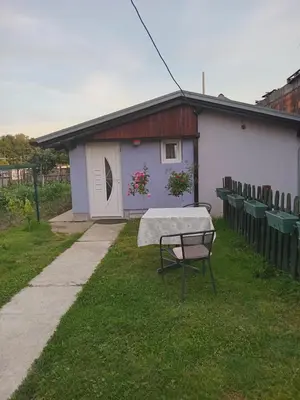 a small house with a table in the grass at Apartmani Primus in Bosanska Gradiška