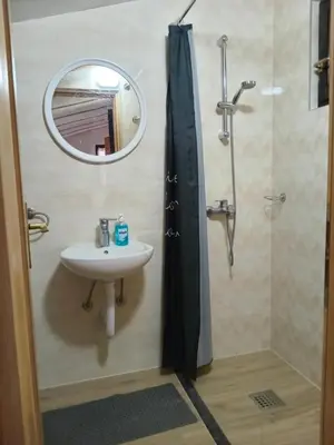 a bathroom with a sink and a shower with a mirror at Apartmani Primus in Bosanska Gradiška