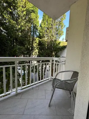 a chair sitting on a balcony with a railing at Apartment Riverstone Retreat in Jajce