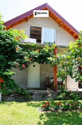 a house with a table and chairs in front of it at Apartman Kestenovac in Orašac
