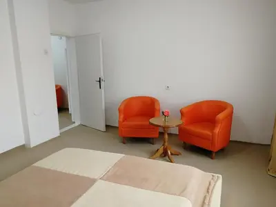 two orange chairs and a table in a room at Apartmani Mušinbegović1 in Visoko