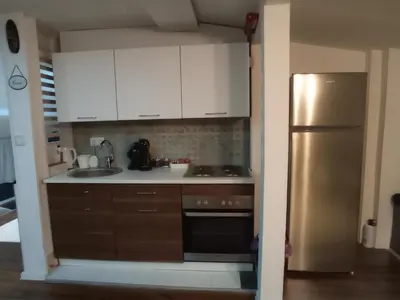 a kitchen with white cabinets and a stainless steel refrigerator at DAMI 2 in Tuzla