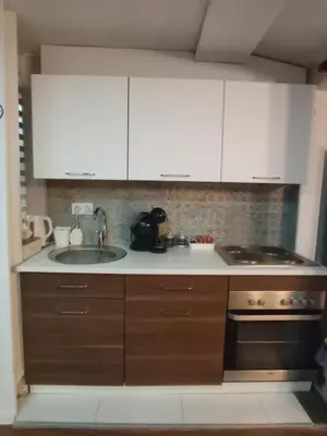 a kitchen with white cabinets and a sink and a stove at DAMI 2 in Tuzla
