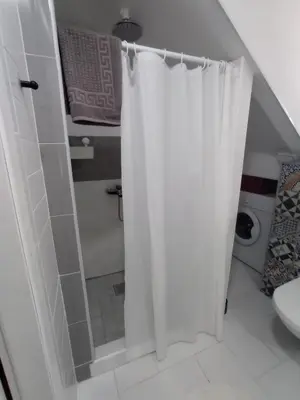 a bathroom with a shower curtain and a toilet at DAMI 2 in Tuzla