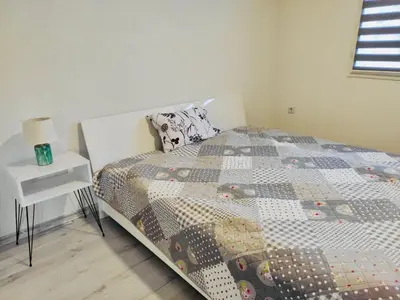 a bedroom with a bed with a quilt on it at Apartman Mir in Visoko