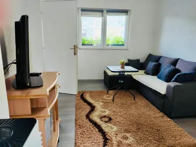 a living room with a couch and a tv at Apartman Mir in Visoko