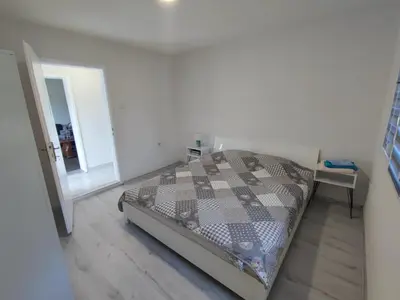 a bedroom with a bed and a mirror at Apartman Mir in Visoko