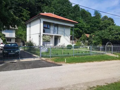 a fence in front of a white house at Apartman Mir in Visoko