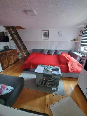 a bedroom with a red bed and a table at Vareš in Vareš