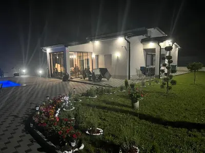 a house at night with flowers in a yard at Villa Lux in Bosanska Krupa