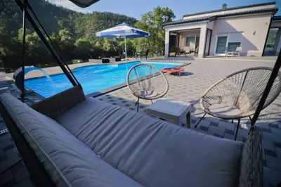 a swing with two chairs and a swimming pool at Villa Lux in Bosanska Krupa