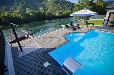 a large swimming pool with a view of a river at Villa Lux in Bosanska Krupa