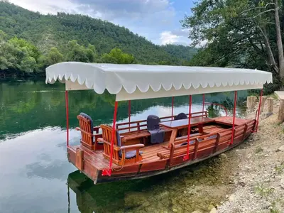 a boat with chairs on the water on a lake at Villa Lux in Bosanska Krupa