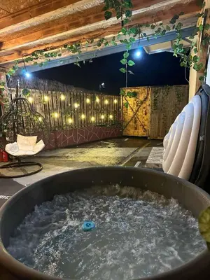 a bath tub filled with water in a room with lights at Barok in Tešanj