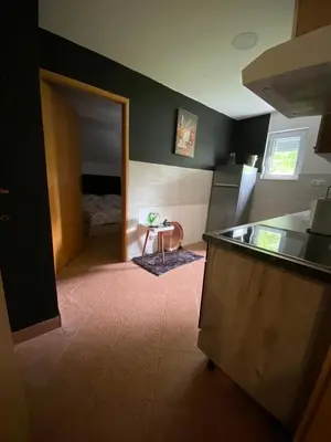 a kitchen with a counter and a room with a bed at Barok in Tešanj