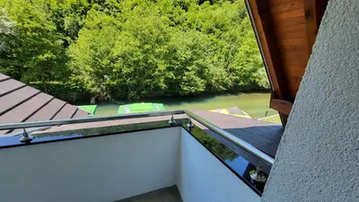 a balcony with a view of a river and trees at Janjska Kuća in Šipovo