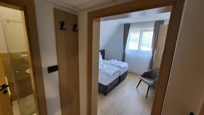 a bedroom with a bed and a window and a chair at Janjska Kuća in Šipovo