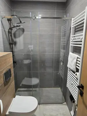 a bathroom with a glass shower with a toilet at Janjska Kuća in Šipovo