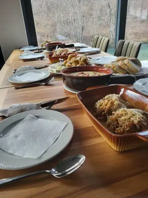 a long wooden table with plates and bowls of food at Janjska Kuća in Šipovo