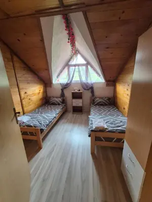 an attic room with two beds and a window at Un Rio Sana in Gornji Ribnik