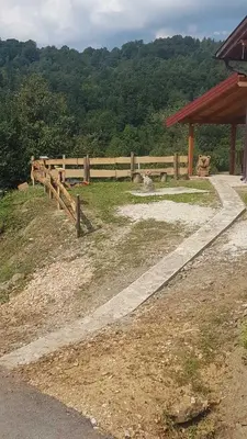 a wooden fence with a person sitting in a field at Un Rio Sana in Gornji Ribnik