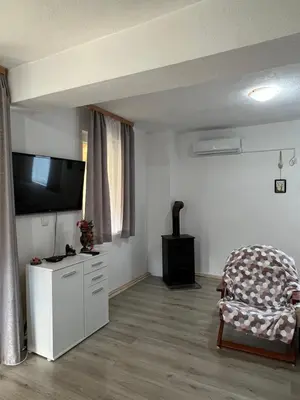 a living room with a flat screen tv and a chair at Un Rio Sana in Gornji Ribnik