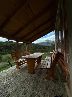 a picnic table and benches on the side of a building at Un Rio Sana in Gornji Ribnik