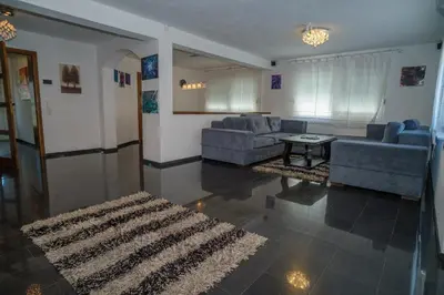 a living room with two blue couches and a rug at Sarajevo Villa Sunce in Ilijaš