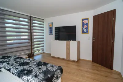 a bedroom with a bed and a flat screen tv at Sarajevo Villa Sunce in Ilijaš