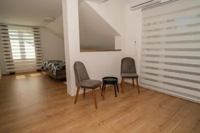 two chairs and a table in a room with a bed at Sarajevo Villa Sunce in Ilijaš