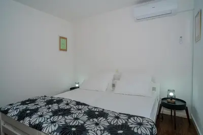 a bedroom with a bed with a black and white comforter at Sarajevo Villa Sunce in Ilijaš