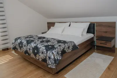 a bedroom with a bed with a black and white blanket at Sarajevo Villa Sunce in Ilijaš