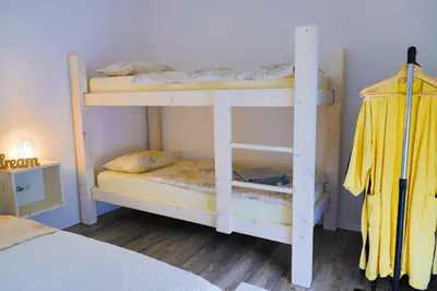 two white bunk beds in a room with a bed at Villa Bubinka in Bihać